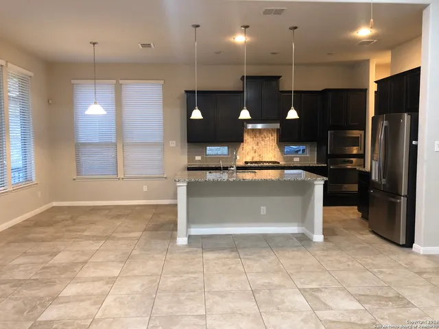 a view of kitchen with a refrigerator and a sink