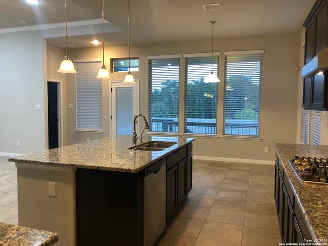 a kitchen with stainless steel appliances granite countertop a sink and a refrigerator