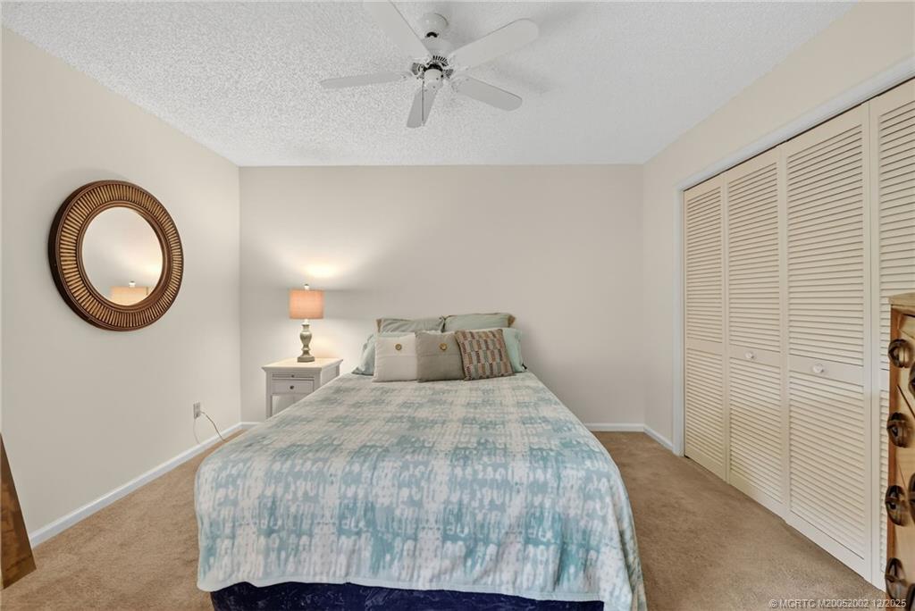 3460 Southeast Martinique Trace, Unit 103 Stuart, FL 34997 - Photo 19 of 42 a bedroom with a bed and a window