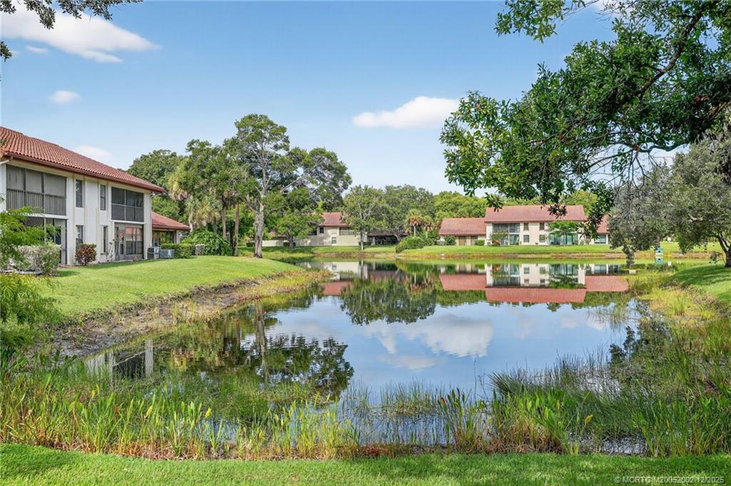 3460 Southeast Martinique Trace, Unit 103 Stuart, FL 34997 - Photo 2 of 42 a view of a house with a yard and potted plants
