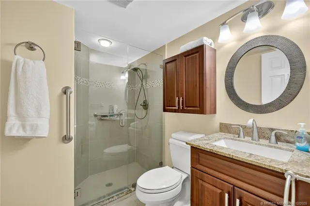 a bathroom with a granite countertop toilet a sink and a mirror