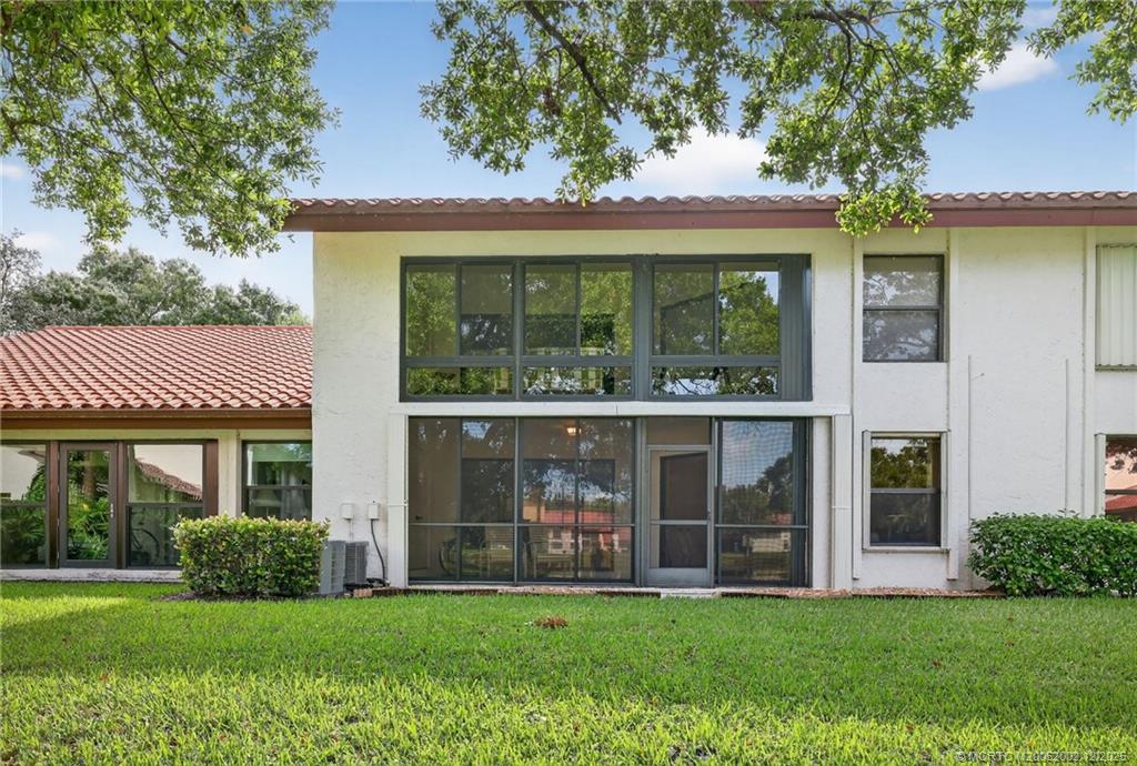 3460 Southeast Martinique Trace, Unit 103 Stuart, FL 34997 - Photo 27 of 42 a front view of a house with a yard