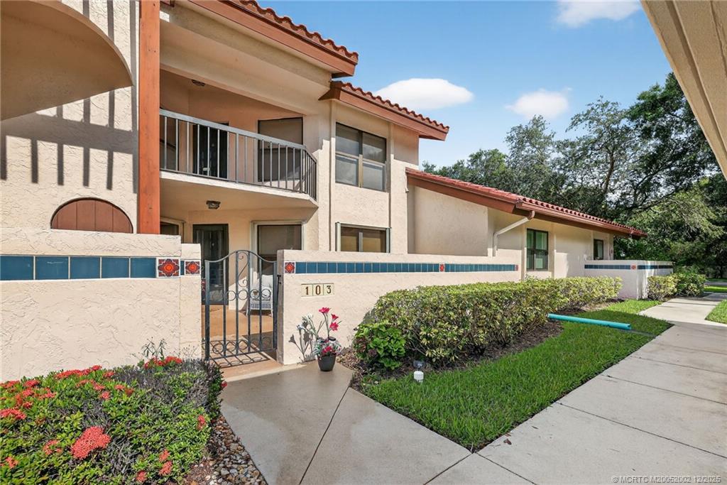 3460 Southeast Martinique Trace, Unit 103 Stuart, FL 34997 - Photo 3 of 42 a front view of a house with a yard
