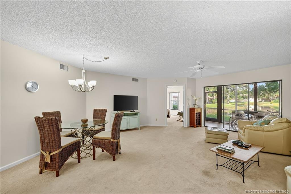 3460 Southeast Martinique Trace, Unit 103 Stuart, FL 34997 - Photo 7 of 42 a living room with furniture and a flat screen tv