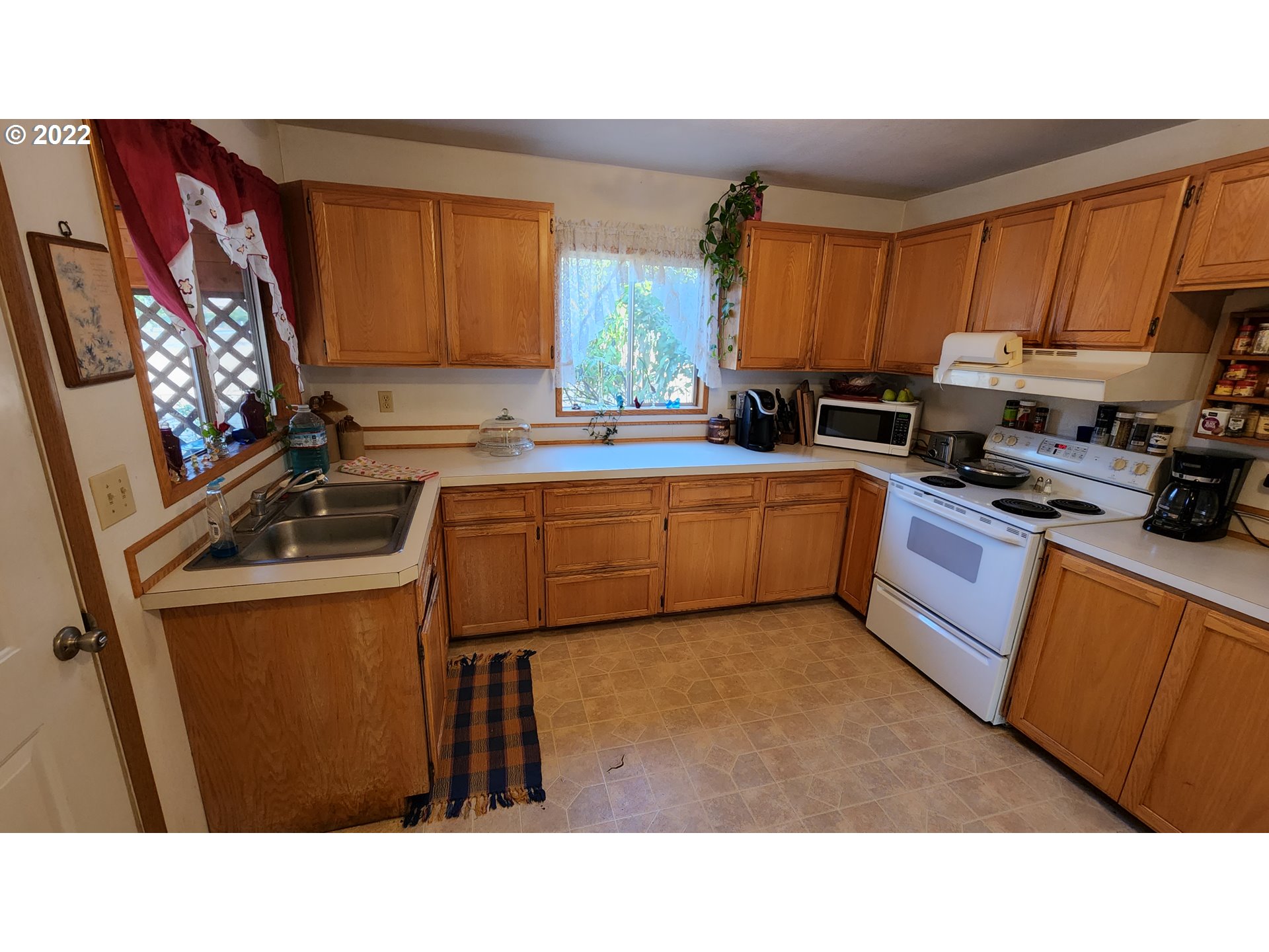 5208 Riddle Bypass Road Riddle, OR 97469 - Photo 12 of 37 a kitchen with stainless steel appliances a sink a stove a refrigerator cabinets and a window