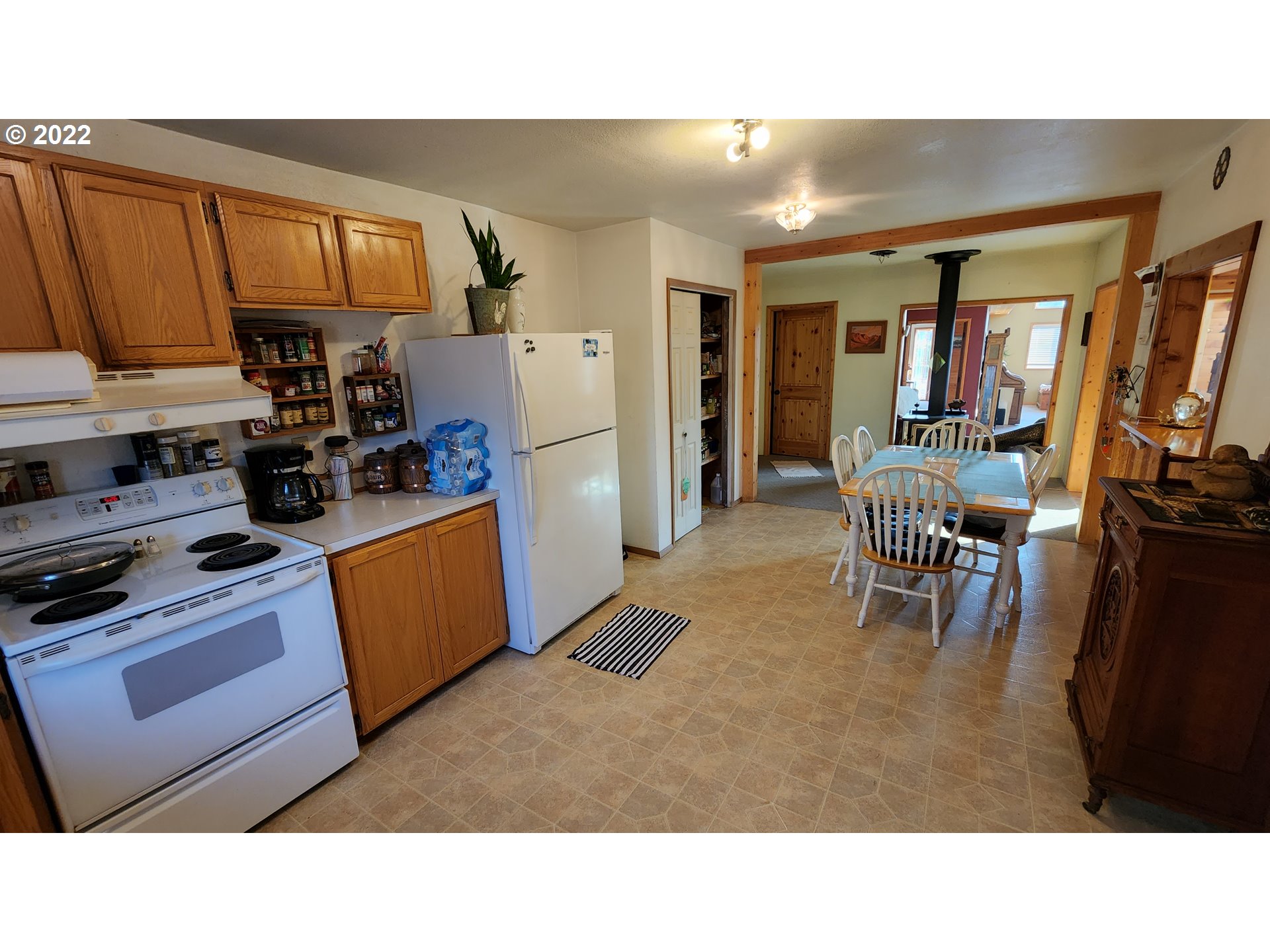 5208 Riddle Bypass Road Riddle, OR 97469 - Photo 13 of 37 a kitchen with stainless steel appliances kitchen island granite countertop a refrigerator a stove top oven and a sink with large countertops