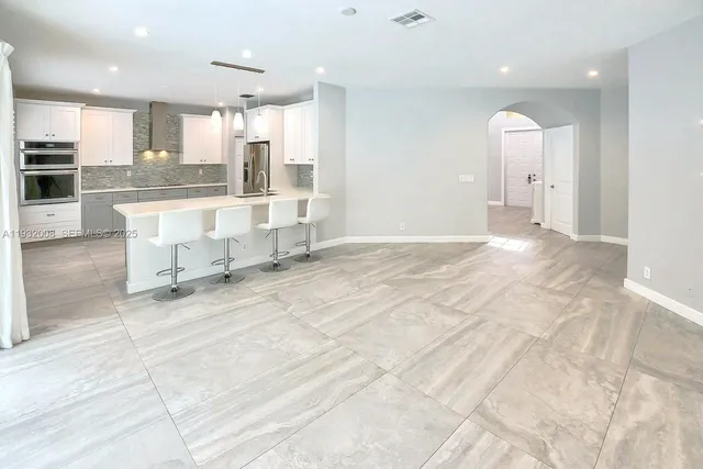 a kitchen with a large window appliances and cabinets