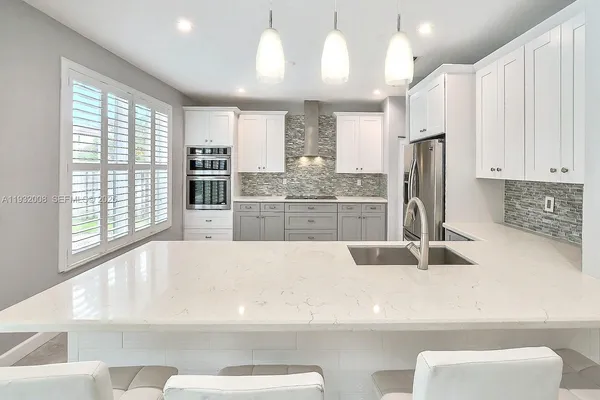 a kitchen with stainless steel appliances kitchen island granite countertop a stove a sink and a refrigerator