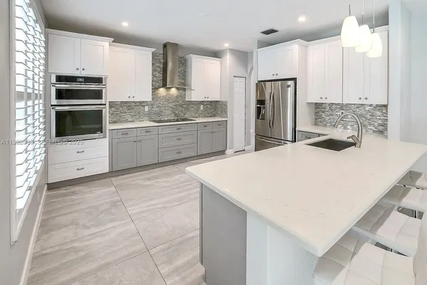 a kitchen with white cabinets and white appliances