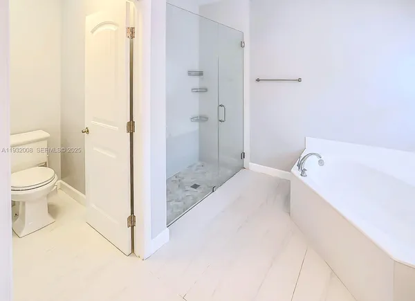 a spacious bathroom with a double vanity sink mirror and bathtub
