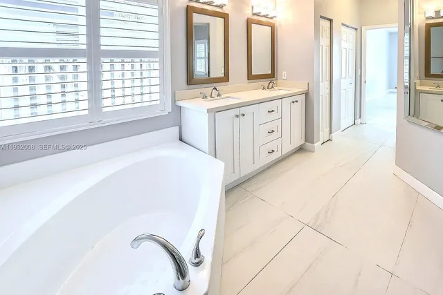 a bathroom with a tub sink and mirror