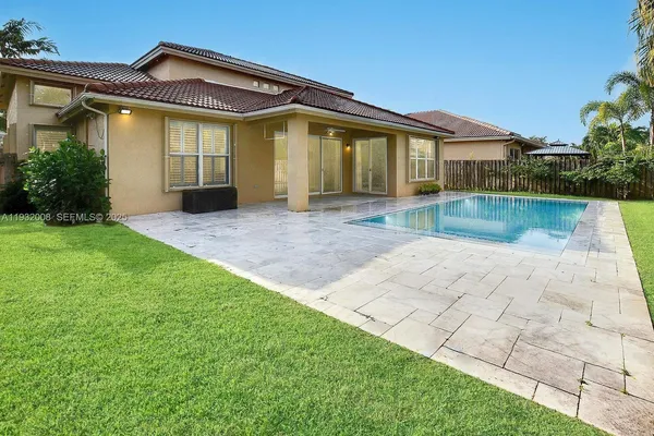 a view of swimming pool with a yard and palm trees