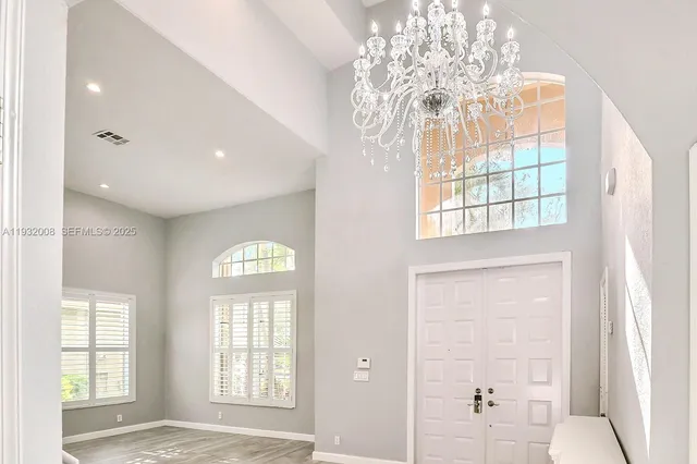 a view of an empty room with a window and a chandelier
