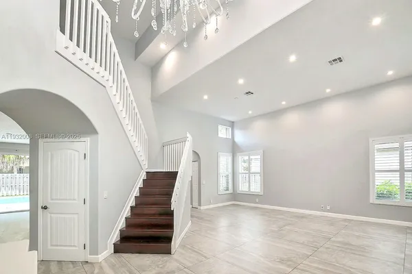a view of a kitchen with kitchen island a large window cabinets a sink and a counter top space