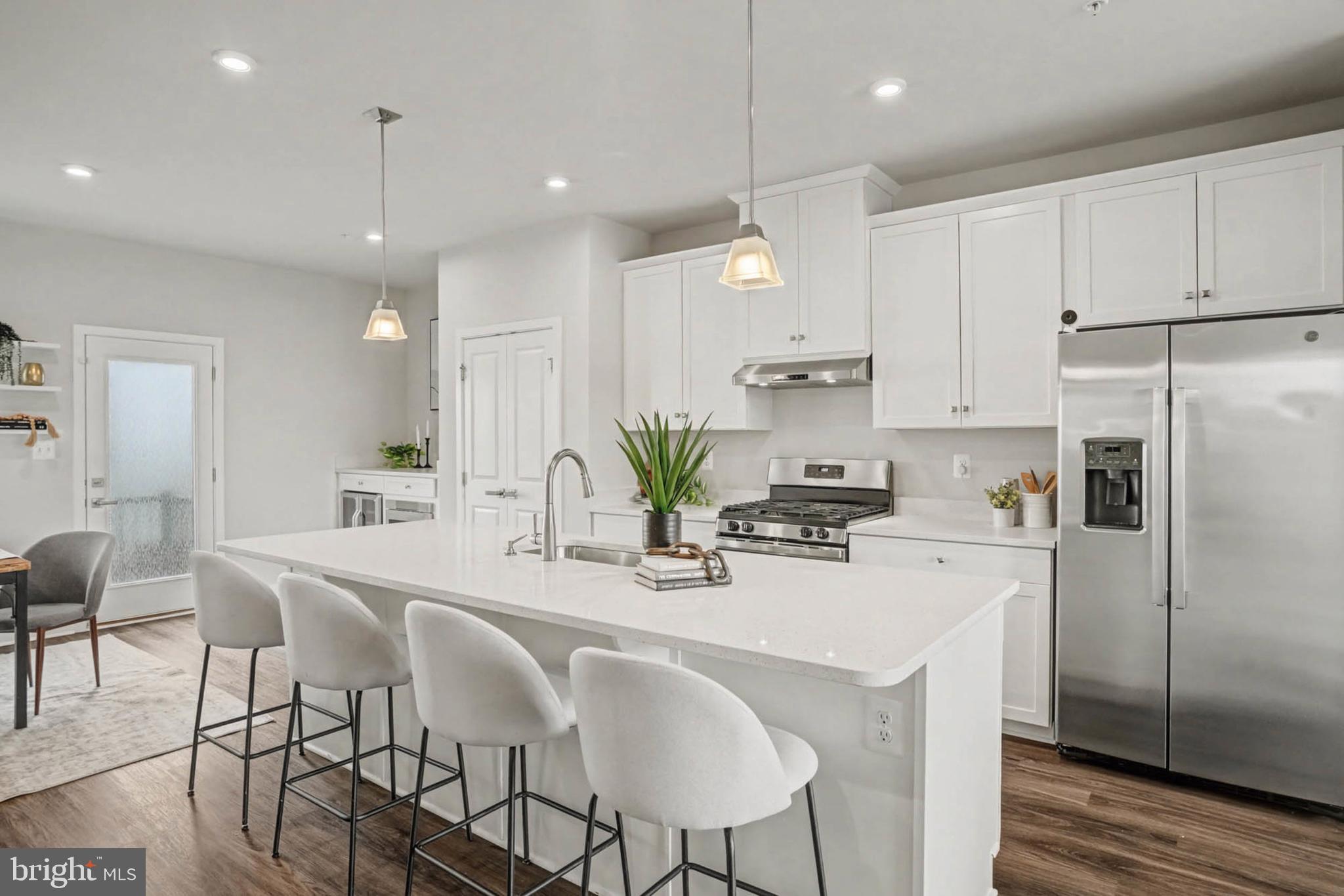 1518 Decatur Street, Unit C Baltimore, MD 21230 - Photo 5 of 42 a kitchen with stainless steel appliances kitchen island granite countertop a dining table chairs refrigerator and microwave