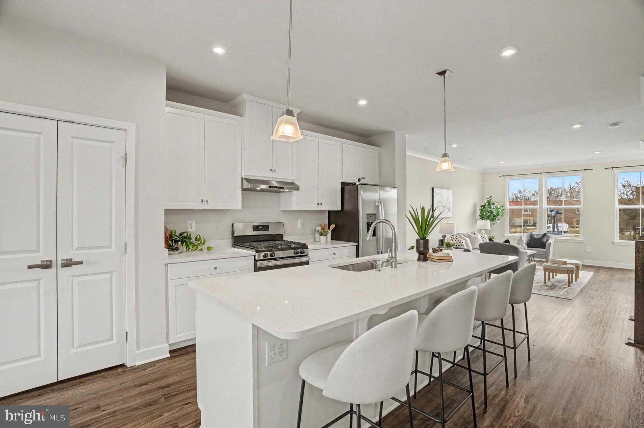 1518 Decatur Street, Unit C Baltimore, MD 21230 - Photo 6 of 42 a kitchen with stainless steel appliances kitchen island granite countertop a stove a refrigerator a kitchen island a dining table and chairs with wooden floor