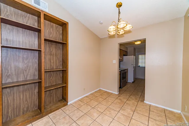 a view of kitchen with refrigerator and cabinets