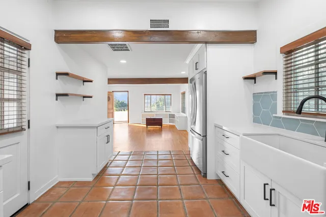 a hallway with white cabinets and wooden floor