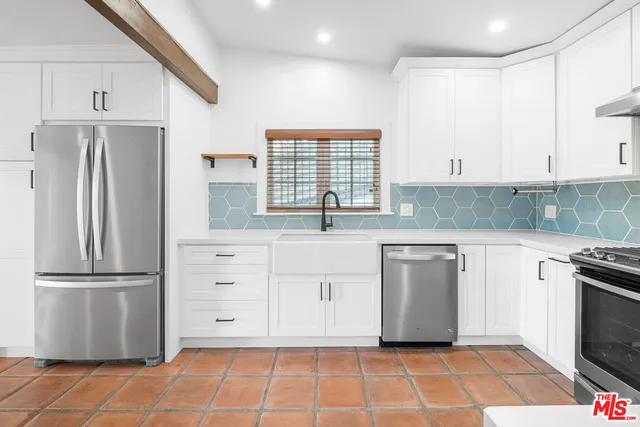a kitchen with stainless steel appliances granite countertop a refrigerator sink and cabinets