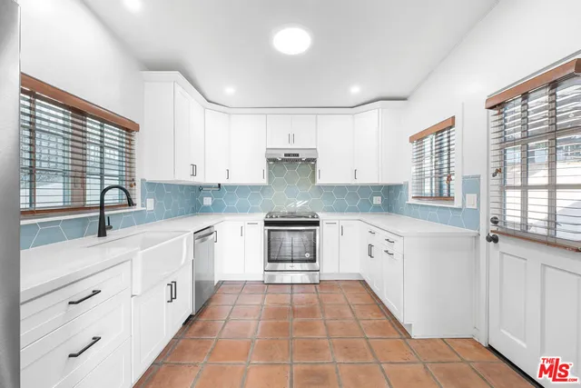 a kitchen with granite countertop white cabinets and white appliances