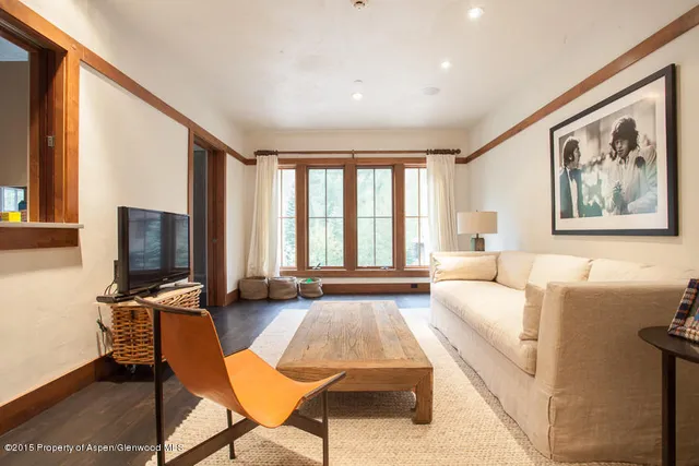 a living room with furniture a flat screen tv and large window