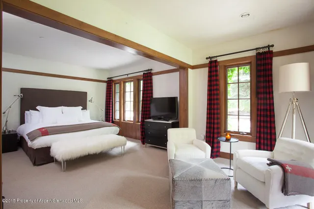 a bedroom with a bed couch and a large window