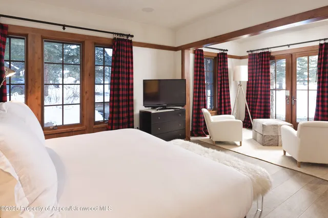 a bedroom with a large bed and a flat tv screen