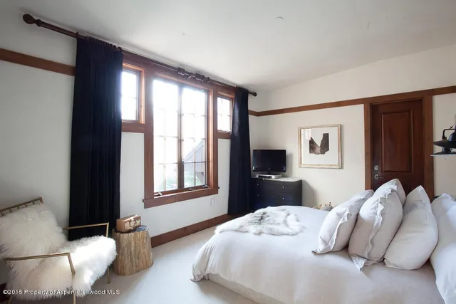 a bedroom with a bed and a large window