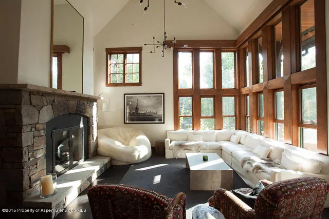 a living room with furniture fireplace and a large window