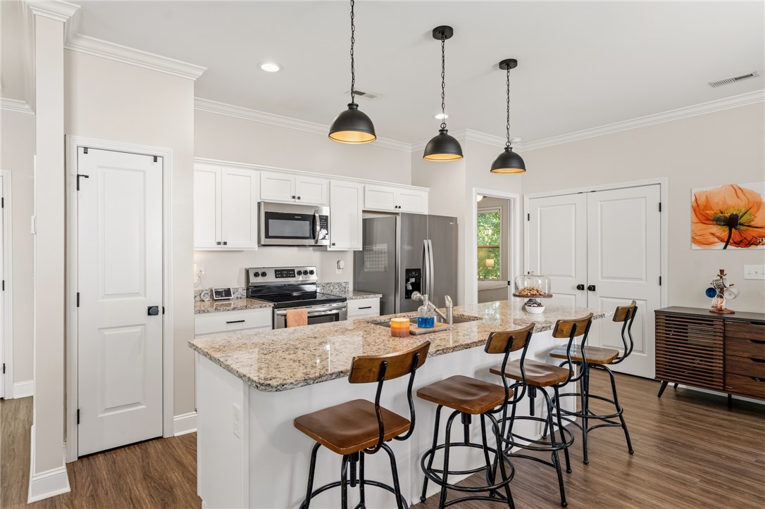 47 A Main Street Pelzer, SC 29669 - Photo 4 of 27 This modern kitchen features a spacious island and stainless steel appliances, perfect for everyday living.