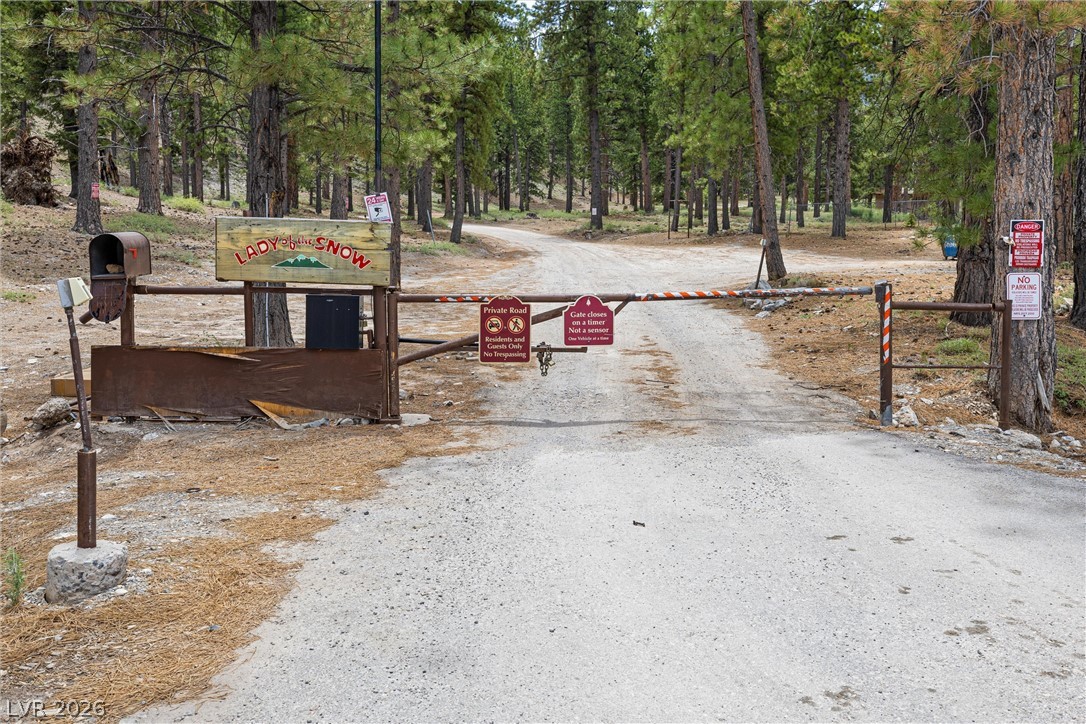 2146 Via Spes Nostra Street Mount Charleston, NV 89124 - Photo 30 of 33 Secure access to a secluded woodland retreat through a private road entrance.