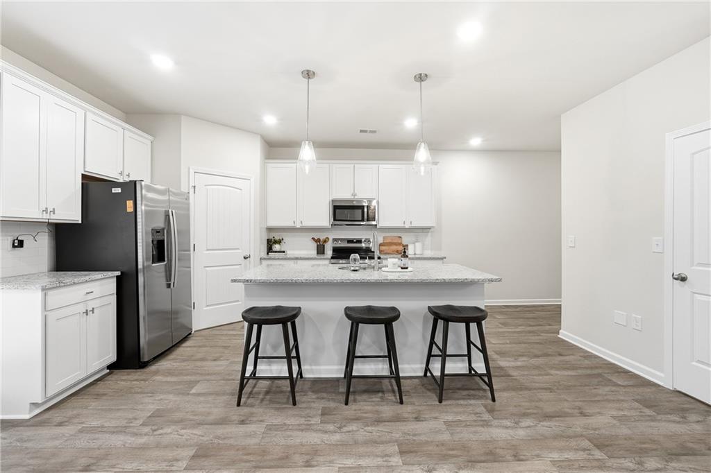 3227 Winding Waters Way, Unit 36 Powder Springs, GA 30127 - Photo 11 of 30 a kitchen with refrigerator cabinets and wooden floor