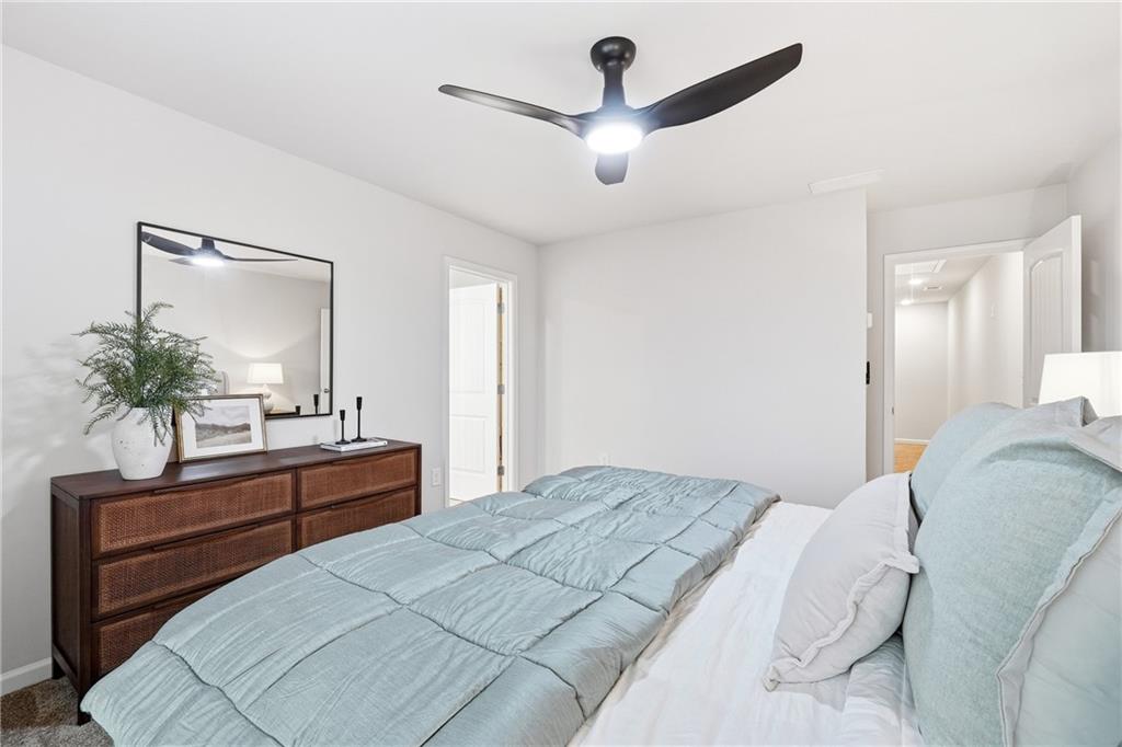 3227 Winding Waters Way, Unit 36 Powder Springs, GA 30127 - Photo 16 of 30 a bedroom with a large bed and a chandelier