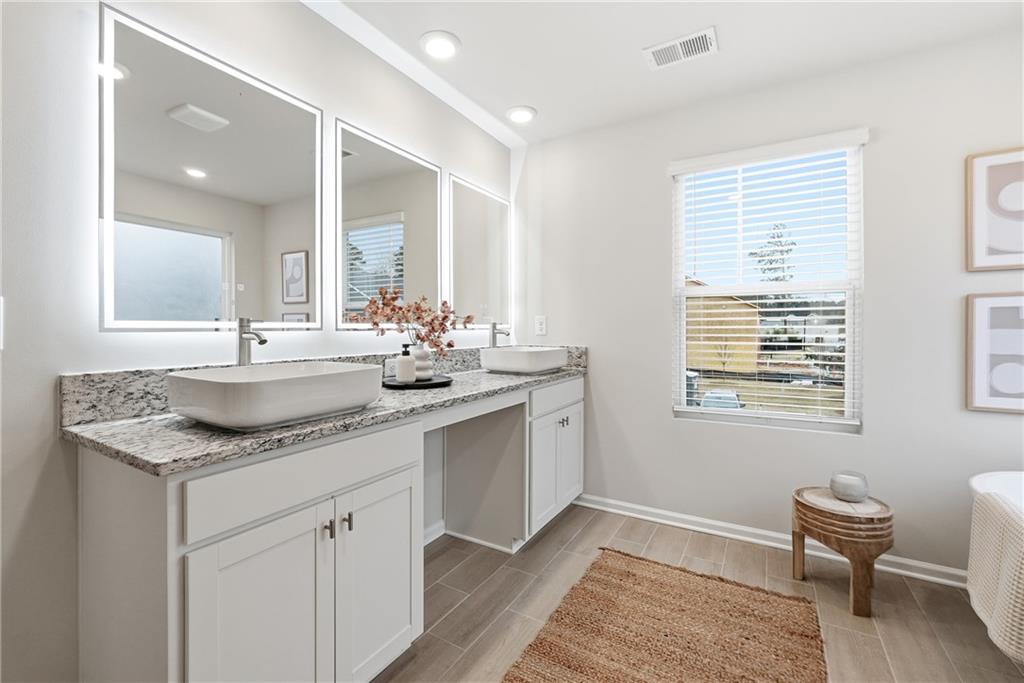 3227 Winding Waters Way, Unit 36 Powder Springs, GA 30127 - Photo 17 of 30 a bathroom with a granite countertop sink and a window