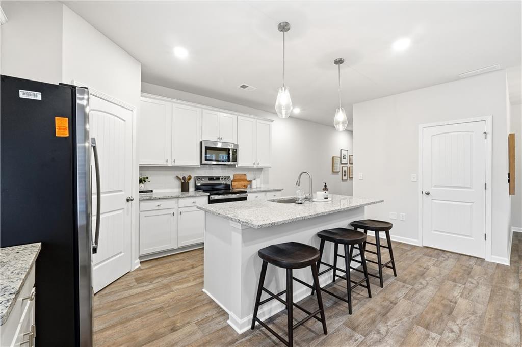 3227 Winding Waters Way, Unit 36 Powder Springs, GA 30127 - Photo 10 of 30 a kitchen with stainless steel appliances a stove a sink a refrigerator a center island and cabinets