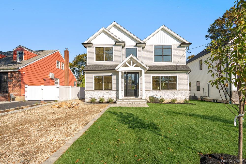 a front view of a house with a garden and yard