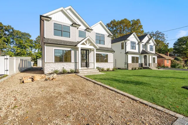 a front view of a house with a garden and yard