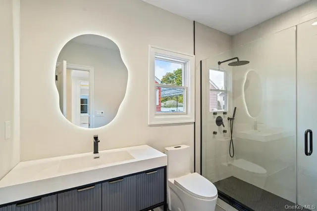 a large kitchen with stainless steel appliances granite countertop a large counter top a wooden floor and windows