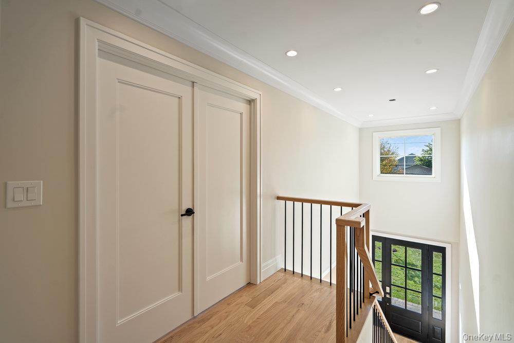 47 Netz Place Albertson, NY 11507 - Photo 18 of 41 Corridor featuring ornamental molding, recessed lighting, light wood-style floors, and an upstairs landing