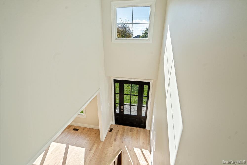 47 Netz Place Albertson, NY 11507 - Photo 30 of 41 Doorway to outside featuring healthy amount of natural light, wood finished floors, and a towering ceiling