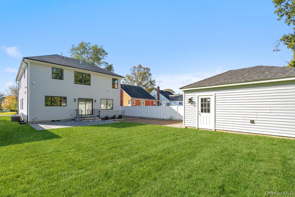 47 Netz Place Albertson, NY 11507 - Photo 34 of 41 Rear view of house with a patio and roof with shingles