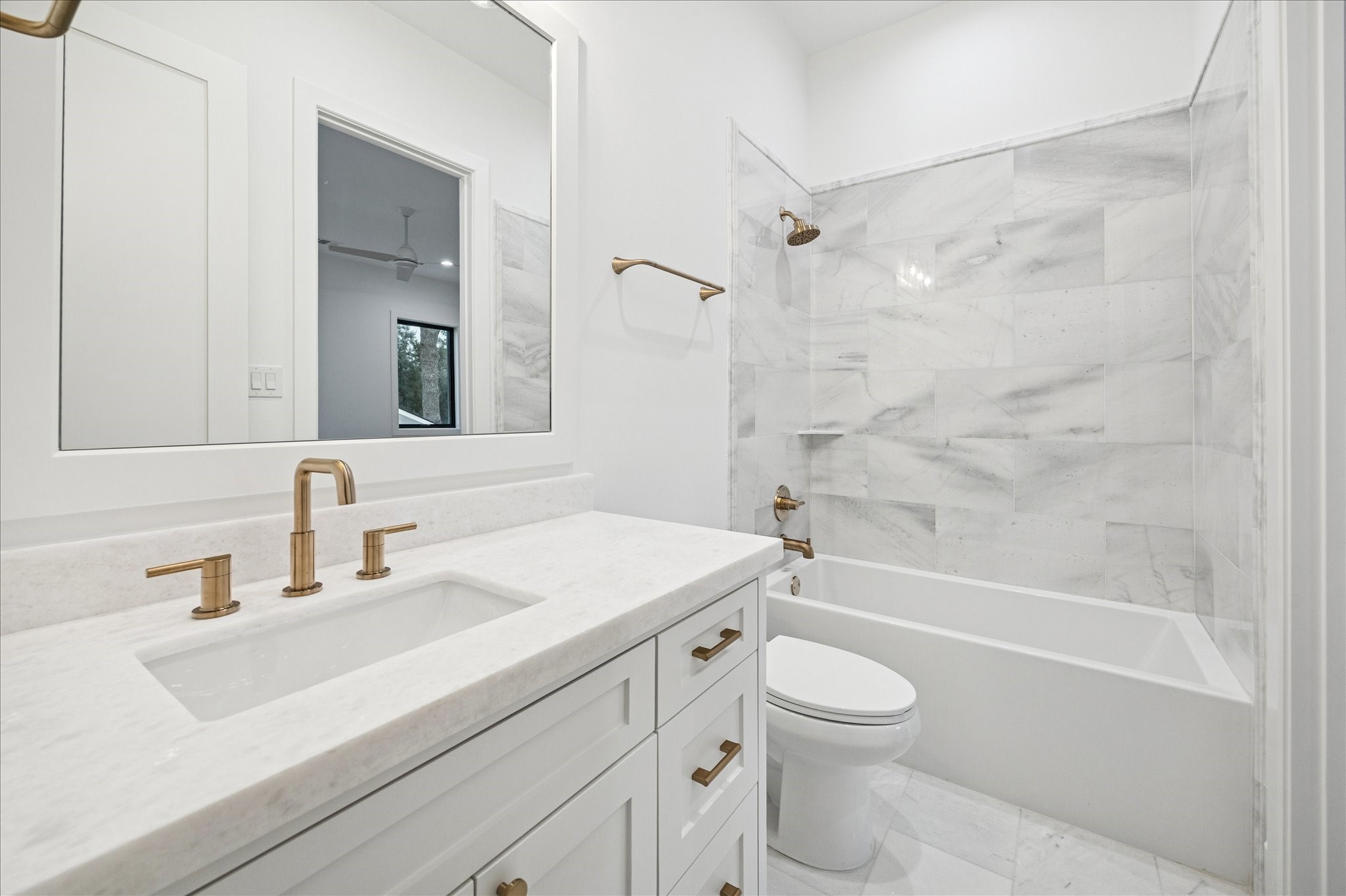 830 Azalea Street Houston, TX 77018 - Photo 27 of 50 Crisp white finishes, streamlined brass fixtures, and large-format tile give this en-suite bath a bright, contemporary look with clean architectural lines.