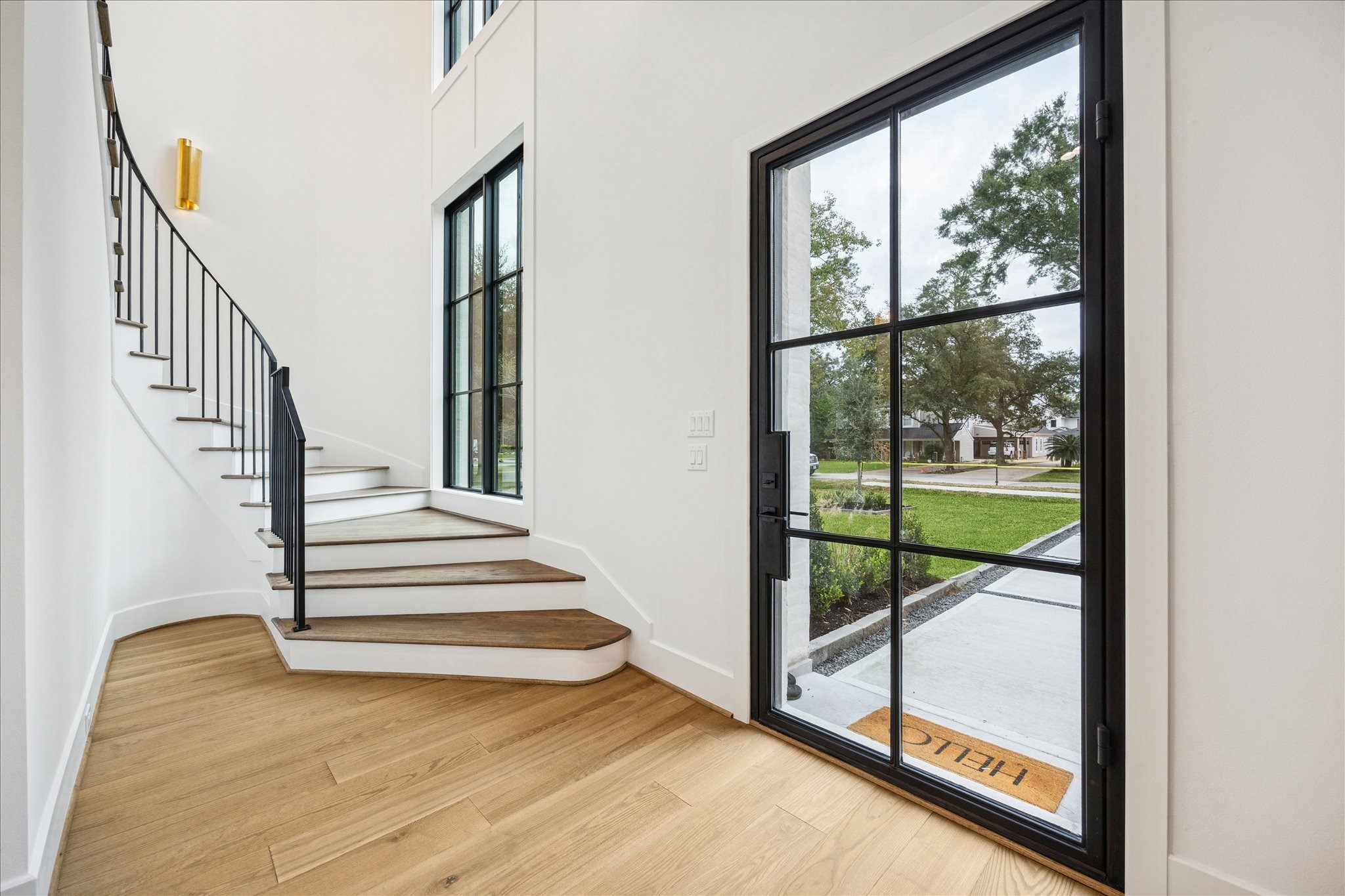830 Azalea Street Houston, TX 77018 - Photo 3 of 50 Floor-to-ceiling Pella Reserve windows illuminate the curved staircase and wide-plank oak floors, creating an open, welcoming entry with elegant vertical volume. Soaring ceiling heights carried throughout the home set this build apart from typical new construction.