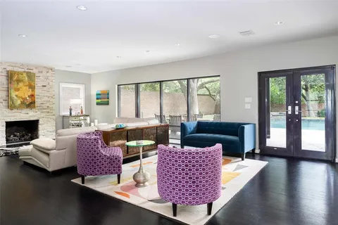 a living room with furniture large window and wooden floor
