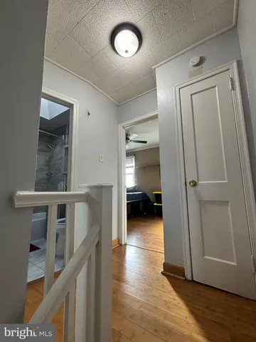 a view of a hallway to a livingroom with furniture and wooden floor