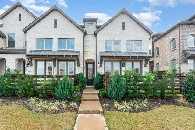 a view of a white house next to a yard