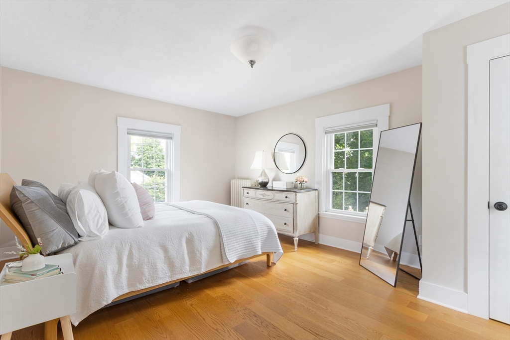 170 West Street, Unit 170 Needham, MA 02494 - Photo 17 of 32 a bedroom with a bed a mirror and a large window with the outer view