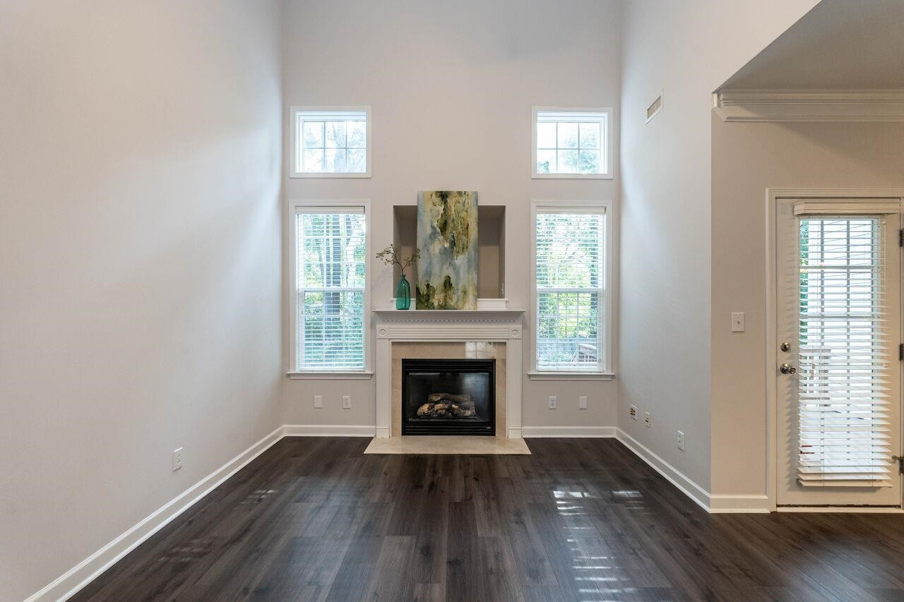 5948 Kohler Lane Raleigh, NC 27616 - Photo 14 of 32 an empty room with wooden floor fireplace and windows
