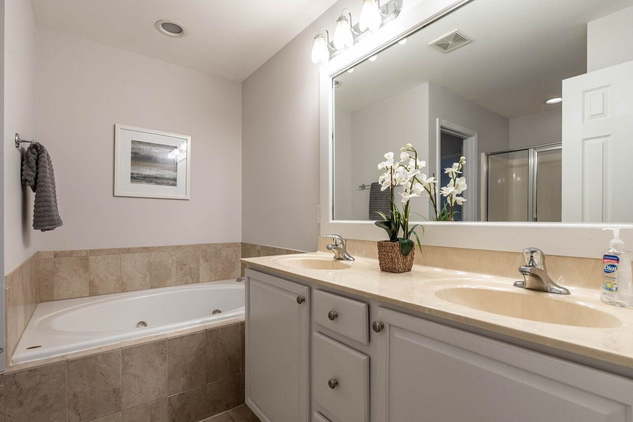 5948 Kohler Lane Raleigh, NC 27616 - Photo 22 of 32 a bathroom with a tub a double vanity sink and a mirror