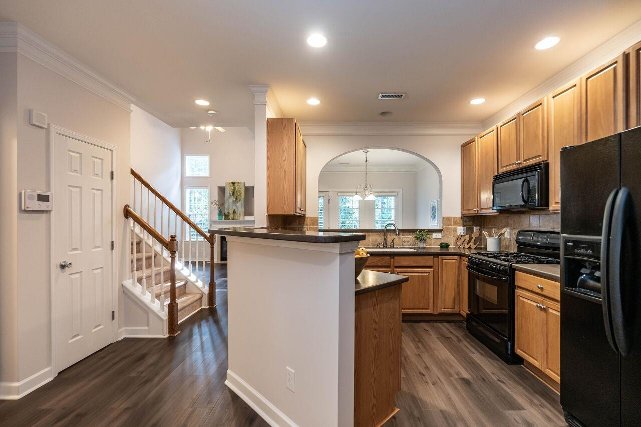 5948 Kohler Lane Raleigh, NC 27616 - Photo 5 of 32 a kitchen with stainless steel appliances granite countertop a refrigerator a stove top oven a sink and dishwasher with wooden floor